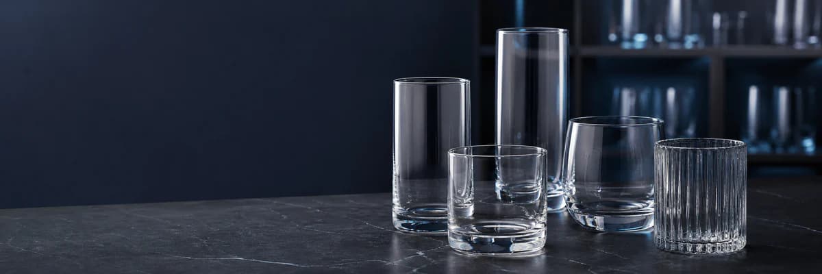 Collection of clear drinking tumblers on a dark showroom surface